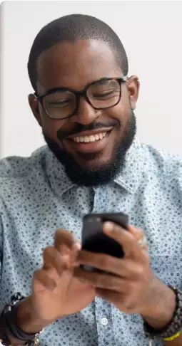 homem utilizando celular e sorrindo homem utilizando celular e sorrindo