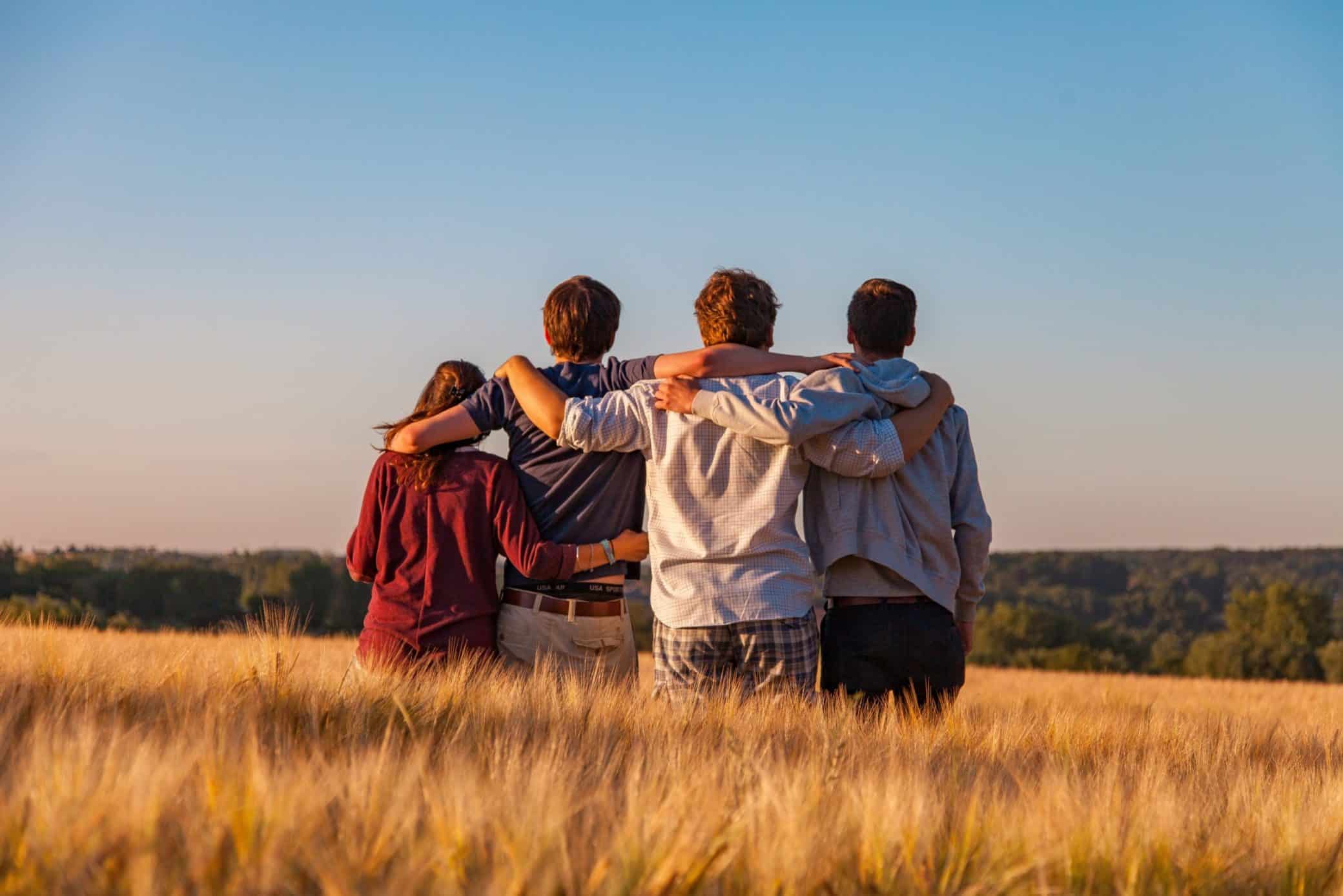 grupo de amigos abrançando na planicie de trigo por do sol o que fazer na quarentena